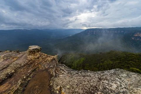 View of deep valley and rolling hills from a rocky cliff edge Stock Photos