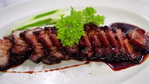 View of delicious char siu served on a plate alongside fresh cucumber slices. Stock-Footage 285286680