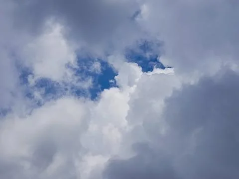 View of dense storm clouds with a small opening of blue sky creating a dramatic Stock Photos