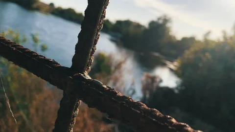 View from deserted house through the window with rusty grates on the lake and Stock Footage 116465228