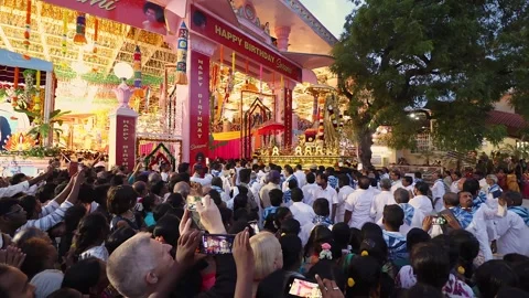 View of devotees watching Golden Chariot procession entering Kulwant Hall. Stock Footage 292838281