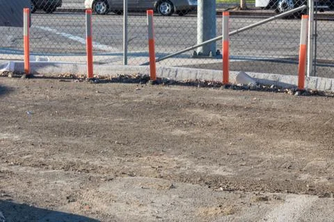 View of dirt construction area alongside a busy street with curb and orange Stock Photos