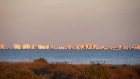 View Of The Distant City On A Large Lake Shore Illuminated By The Setting Sun Stock Footage 229165252