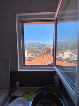 View of distant mountains framed perfectly by an open window, revealing rooft Stock Photos