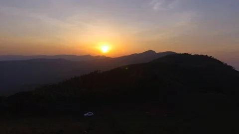 View of distant sunset with lush green mountains 動画素材 90885296