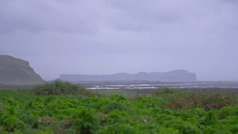 View of distant waves and rock formations with blowing grass in foreground 스톡 동영상 327082746