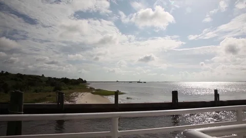 View of dock and beach as a boat leaves the shore Stock Footage 124999814