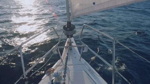View of dolphins swimming in front of bow of yacht during sunset Stock Footage 86562541