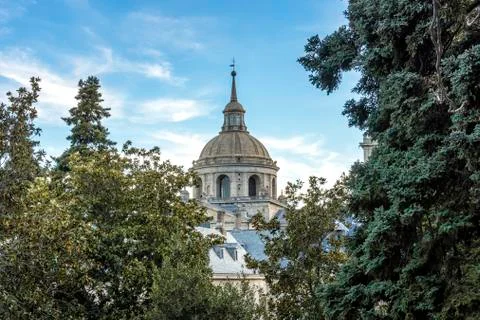 View of a dome of the Escorial monastery surrounded by trees. Spain madrid. Stock Photos