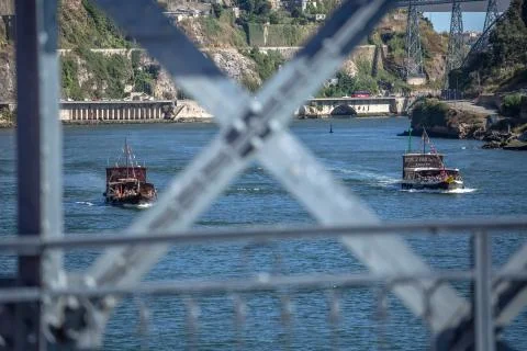 View of Douro river and two recreational boats, with tourists, blur bridge me Stock Photos