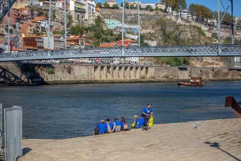View at the Douro river, iconic D. Luis bridge and tourist people seat Stock Photos