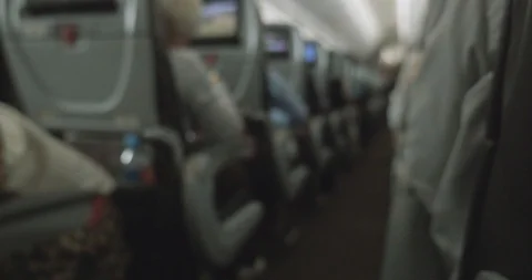 View down the aisle on a plane of passengers sitting in their seats Video stock 107474591
