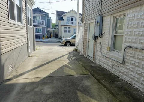 View down the cement driveway from the backyard to the street of two houses t Stock Photos