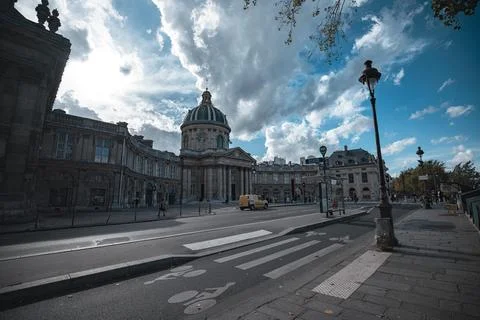 A view down a cobbled street in Paris, France, with a grand building on the left Fotos de archivo