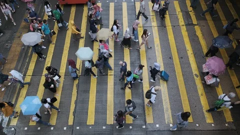View down to crosswalk throng crowdy people flow crossing the street in peak hou Stock Footage 106368176