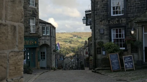 View down hill cobblestone Main Street in shade to sunny countryside Video stock 96657514