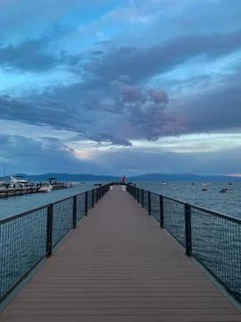 View Down a Pier on Lake Tahoe Against a Dramatic Sky Stock Photos