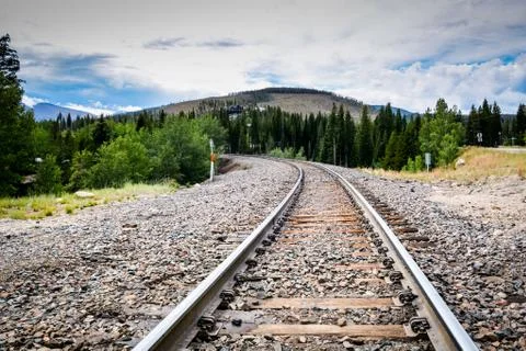 View down the railway tracks onto a forest Stock Photos