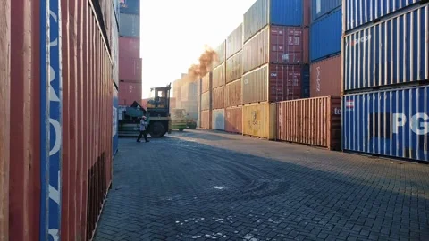 View down a row between tall stacks of shipping containers Stock Footage 312021647