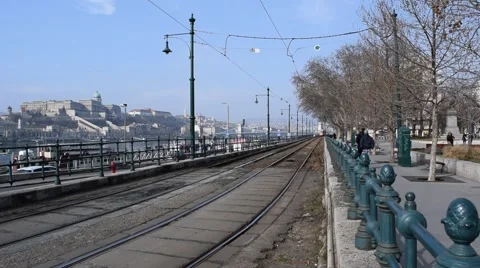 View Down a Tram Track in Budapest. A Tram Comes to a Stop &amp; Buda Castle Stock Footage 47705921