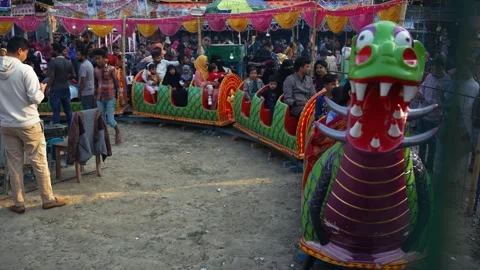 View of a dragon-themed miniature train ride at a fair, Bangladesh. Stock Footage 335015724