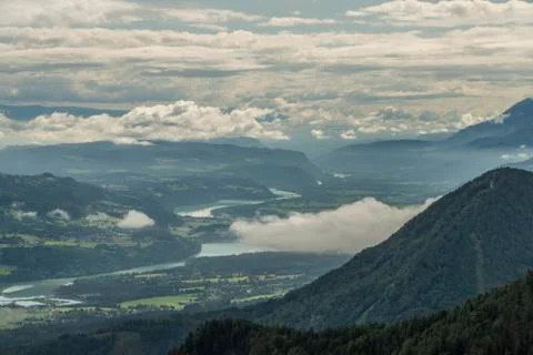 View on Drau river valley from path to Mittagskogel hill in cloudy summer day Stock Photos