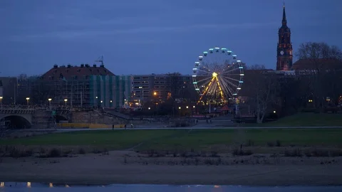 View of Dresden Ferris wheel from across the river, pedestrians walking along th Stock Footage 124416152
