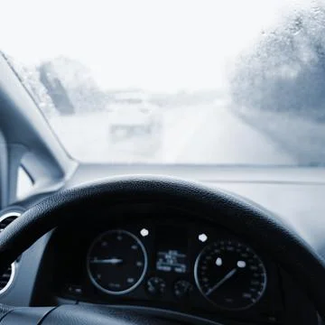View from the driver - car interior with steering wheel and dashboard. Winter Stock Photos