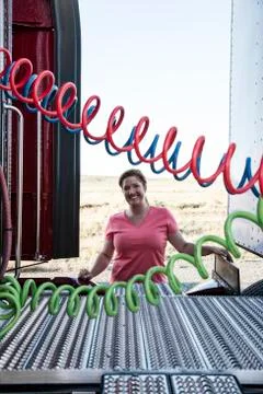 View of a driver connecting the power cords to trailer of a  commercial truck. Stock Photos