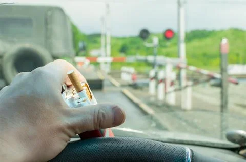 View of the driver hand with a pack of cigarettes Stock Photos