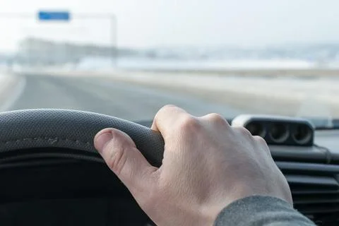 View of the driver hand on the steering wheel of a car Stock Photos
