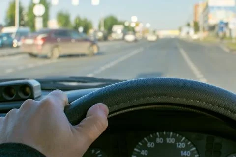 View of the driver hand on the steering wheel of a car Stock Photos