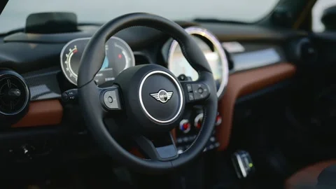 View from the driver seat to steering wheel with Mini Cooper winged logotype Stock Footage 261247683