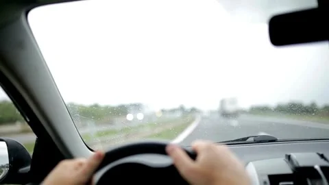 View of the driver's hand on the steering wheel of a car that is driving on the Stock-Footage 336268082