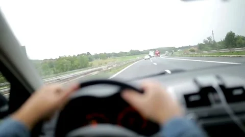 View of the driver's hand on the steering wheel of a car that is driving on the Stock-Footage 336268176