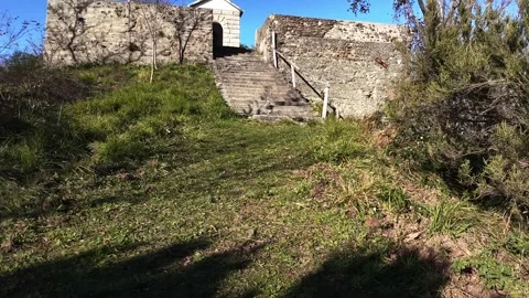 View from a drone flying at eye level above a meadow leading to a chapel Stock Footage 327678107