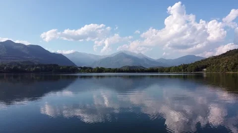 View from drone flying low over surface of lake called Lago di Avigliana Stock Footage 247837669