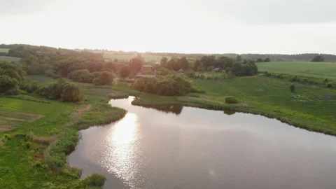 View from a drone flying over a river illuminated by sunlight during sunset. 库存影片 170567175