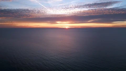 A view from a drone flying over the sea early in the morning at sunrise, with Stock Footage 255772427