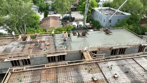 View from drone on foremen spreading and leveling first layer of freshly poured Stock Footage 245959911