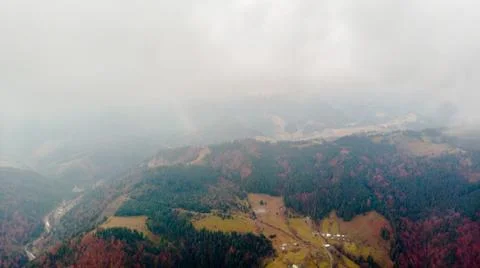 View from a drone to forest, river and village through the fog. Stock Photos