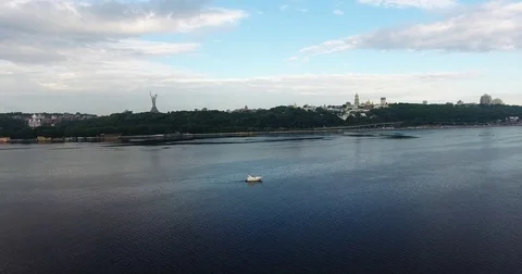 View from drone moving down at the driving yacht along river Dnieper in Kyiv Stock Footage 82657626