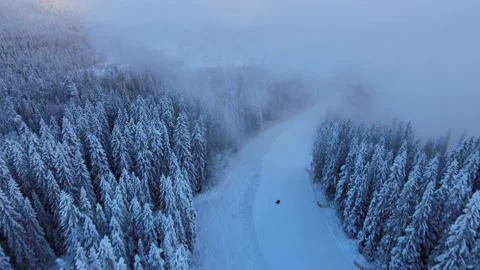 View from drone passing a ski slope and further through snow smoke at sunset Stock Footage 146666710