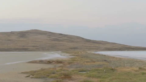 View from the drone on a salt lake with a hill. 4K aerial cinematic video Stock Footage 91584829