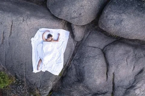 The view from the drone to the white post in the mountains. a sleeping girl on Stock Photos