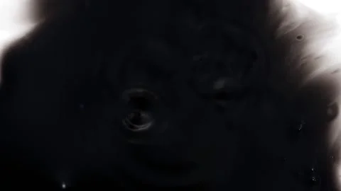 View of dropping black ink over a white background Stock Footage 147700821