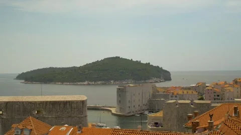 View of Dubrovnik's harbour and rooftops with an island in the distance, Croatia Stock Footage 244013530