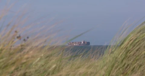 View from a dune edge at a large container ship on high seas Stock Footage 115716170