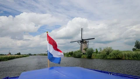 View of the dutch flag and windmills while sailing in the canals Stock Footage 302900024