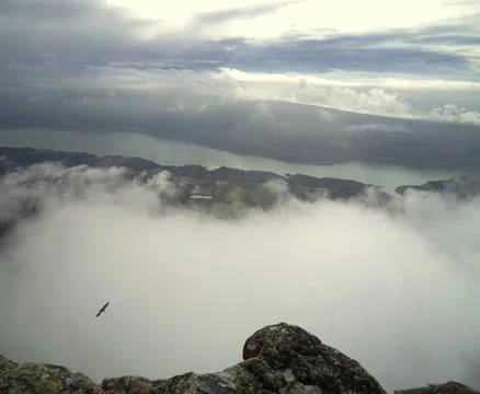 View of eagle flight over mountain top and clouds over river Stock Photos